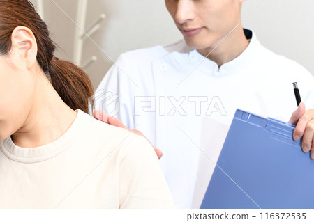 Young Asian woman receiving a checkup from a chiropractor Young Asian woman receiving a checkup from a chiropractor 116372535