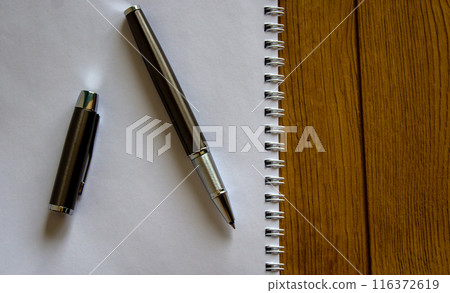 Notebook, pen and cap on beautiful wooden table. Concept background. Notebook, pen and cap on beautiful wooden table. Concept background. 116372619