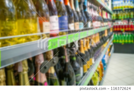 Alcohol showcase blurred background. Blurred abstract background of shelf in supermarket Alcohol showcase blurred background. Blurred abstract background of shelf in supermarket 116372624