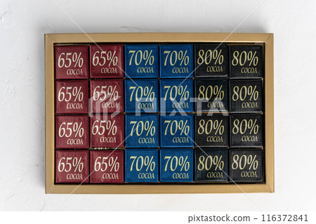 Chocolate squares in gold box, labeled with cocoa content Chocolate squares in gold box, labeled with cocoa content 116372841