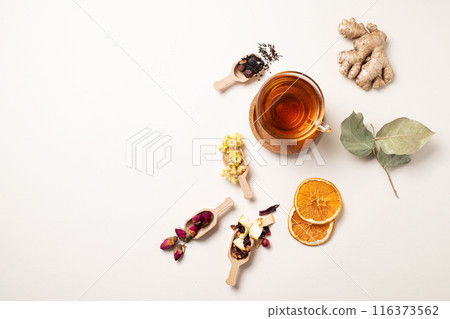 A cup of herbal tea with ginger, dried flowers, fruits and berries. The concept of healthy eating. A cup of herbal tea with ginger, dried flowers, fruits and berries. The concept of healthy eating. 116373562