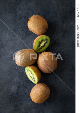 Fresh and sweet kiwi fruits on a dark background. The concept of healthy and dietary food. Top view Fresh and sweet kiwi fruits on a dark background. The concept of healthy and dietary food. Top view 116373609