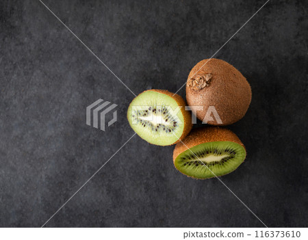 Fresh and sweet kiwi fruits on a dark background. The concept of healthy and dietary food. Top view Fresh and sweet kiwi fruits on a dark background. The concept of healthy and dietary food. Top view 116373610