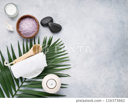 Creative flat lay of facial and body care cosmetics for spa with sea salt, massage stones, candles 116373662