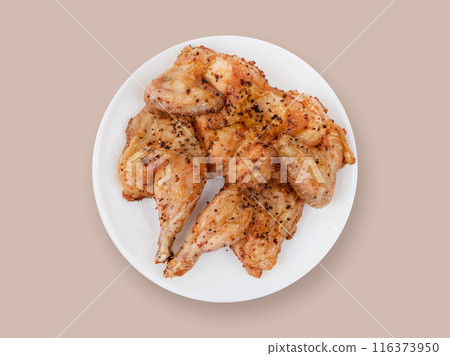 Baked chicken in spices on a white plate on a beige background. Top view 116373950