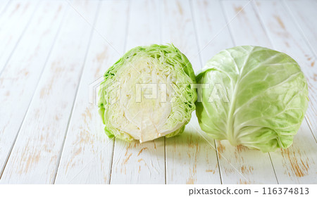 Whole and half green cabbage on a wooden table, copy space for text. Whole and half green cabbage on a wooden table, copy space for text. 116374813