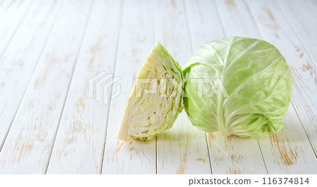 Whole and quarter fresh green cabbage on a light table, copy space for text. Whole and quarter fresh green cabbage on a light table, copy space for text. 116374814