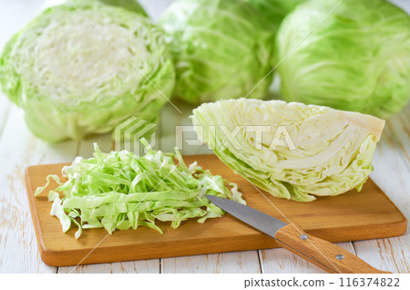 Whole and shredded cabbage on light wooden table. Whole and shredded cabbage on light wooden table. 116374822