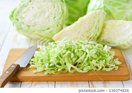 Whole and shredded cabbage on light wooden table. Whole and shredded cabbage on light wooden table. 116374826