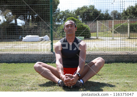 Legs Stretching Pose On The Grass Legs Stretching Pose On The Grass 116375047