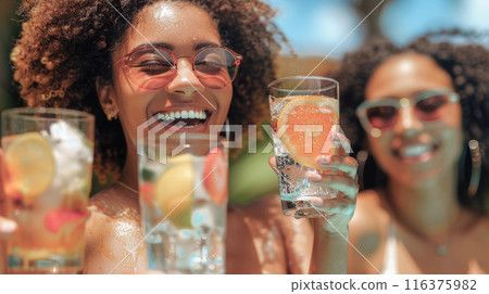 A group of friends relaxing by the pool with colorful cocktails, enjoying a sunny day  116375982