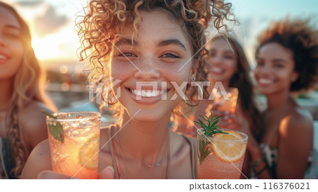 Friends smiling and enjoying refreshing summer drinks with citrus garnishes 116376021
