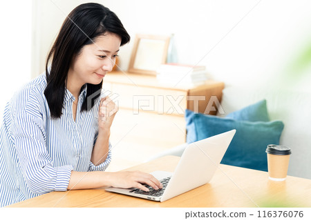 A woman who plays a personal computer in the living room 116376076
