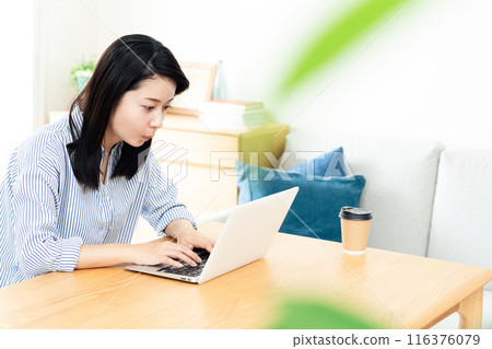 A woman who plays a personal computer in the living room 116376079
