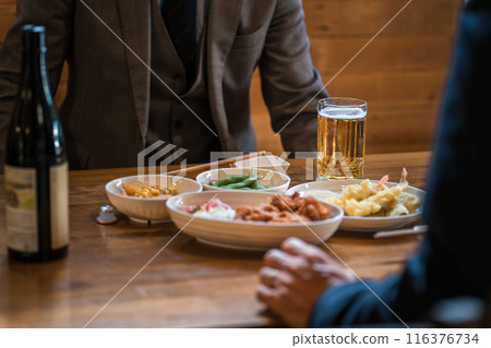 A businessman having fun drinking with his subordinates at an izakaya/bar A businessman having fun drinking with his subordinates at an izakaya/bar 116376734