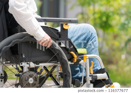 Part cut of a woman in her 30s sitting in a wheelchair Part cut of a woman in her 30s sitting in a wheelchair 116377677