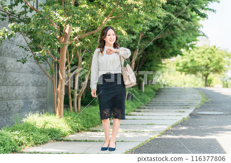 Business woman walking in the office district (watch, schedule, commuting) Business woman walking in the office district (watch, schedule, commuting) 116377806
