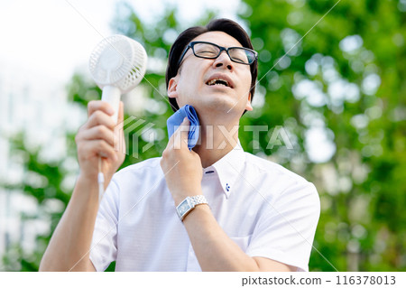 A man walking while wiping sweat 116378013