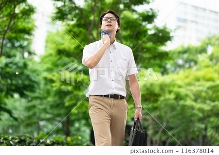 A man walking while wiping sweat 116378014
