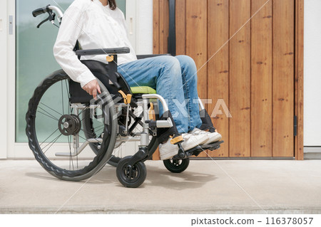 Woman in wheelchair at front door Woman in wheelchair at front door 116378057
