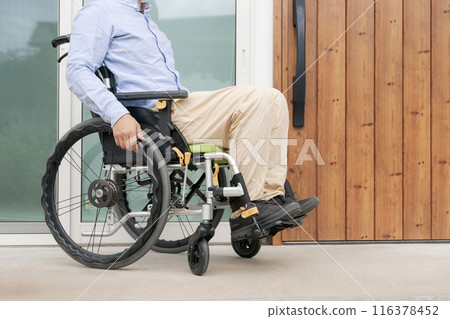 Man in wheelchair at front door 116378452