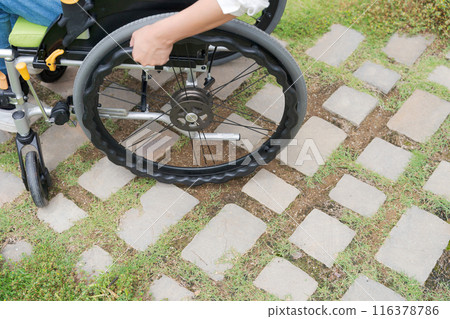 A wheelchair resting on a tiled road 116378786