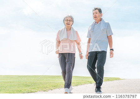 Elderly couple (senior, male and female) walking and aerobic exercise in the park 116378797