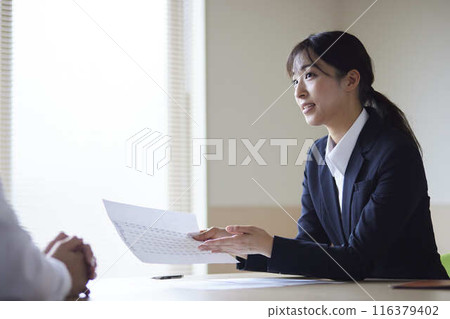 A young female office worker explains documents in a conference room. A young female office worker explains documents in a conference room. 116379402