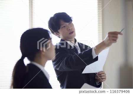 一位男性和一位女性商務人士正在白板前開會。 一位男性和一位女性商務人士正在白板前開會。 116379406