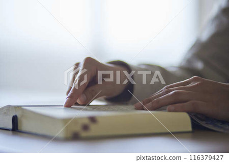 Hands of a university student reading a dictionary Hands of a university student reading a dictionary 116379427