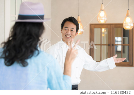Male chef serving customers at a restaurant Welcome 116380422