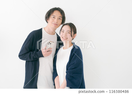 Smiling man and woman with smartphones Smiling man and woman with smartphones 116380486