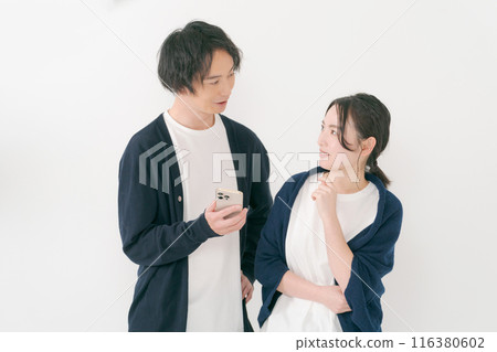 微笑的男人和女人看著智慧型手機 116380602