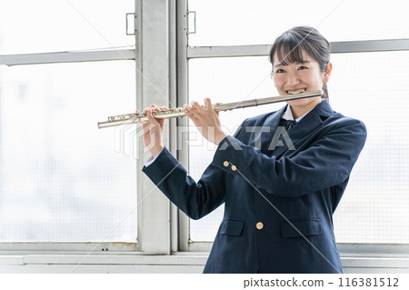 Asian schoolgirl in brass band playing flute in classroom Asian schoolgirl in brass band playing flute in classroom 116381512