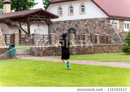 Young white boy running under the water from the sprinkler 116381612