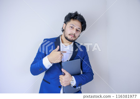 Businessman holding a laptop and pointing at himself 116381977