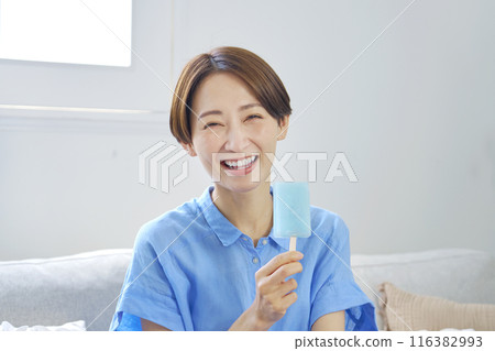 Woman eating ice cream at home Woman eating ice cream at home 116382993