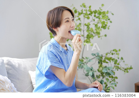 Woman eating ice cream at home Woman eating ice cream at home 116383004