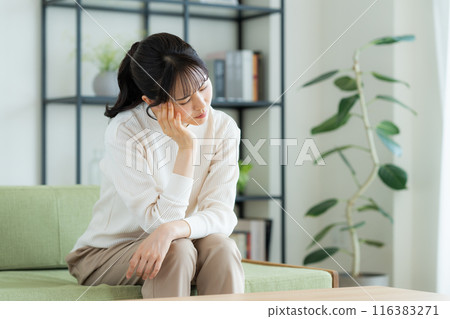 Young woman suffering in the living room Young woman suffering in the living room 116383271