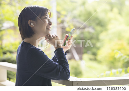 A woman operating a smartphone 116383600