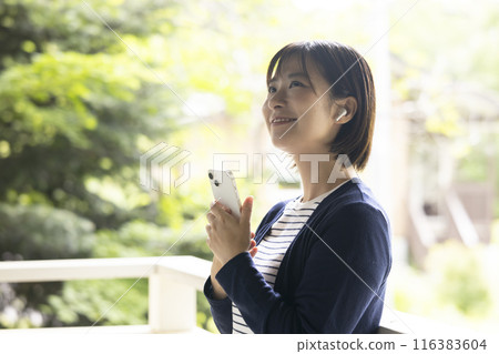 A woman operating a smartphone 116383604