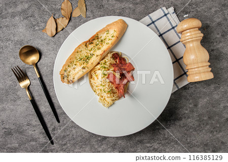 Spaghetti Aglio e Olio with bacon and garlic bread. Spaghetti Aglio e Olio with bacon and garlic bread. 116385129