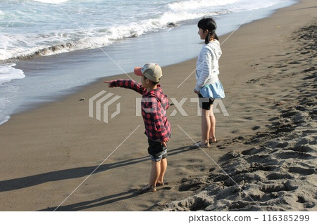 小學生在海灘指著大海,全身從側面 小學生在海灘指著大海,全身從側面 116385299