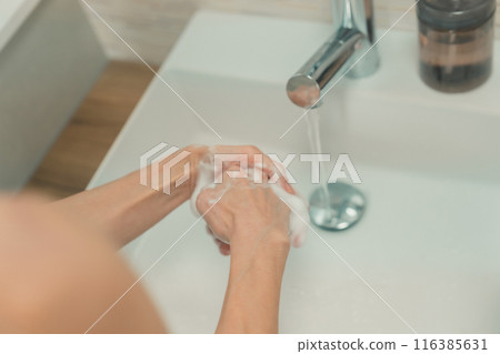 一位 50 多歲的婦女在家水槽裡洗手 116385631