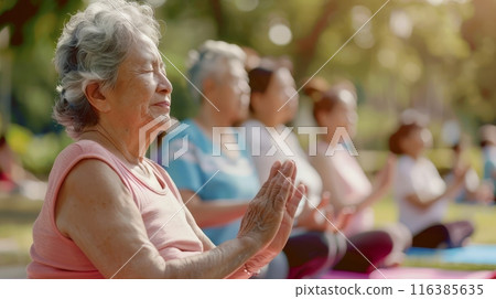 Elderly woman meditating in diverse group yoga 116385635