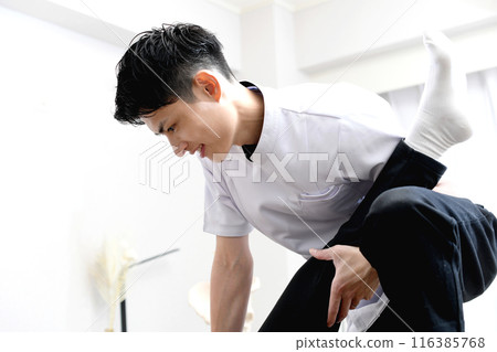 A man giving a massage to a female patient 116385768