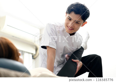 A man giving a massage to a female patient 116385776