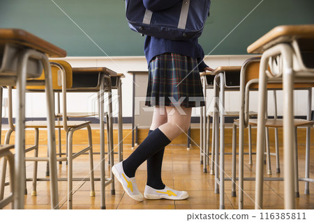 The feet of a female student walking through the classroom 116385811