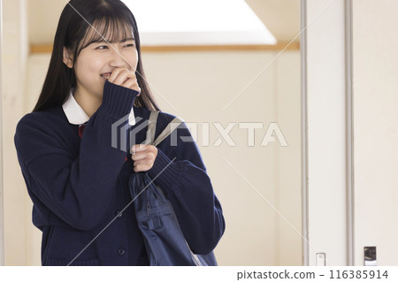 A high school girl comes into the classroom laughing 116385914
