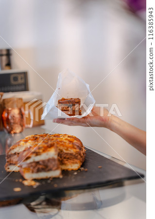 A woman's hands with a wrapped piece of coke to take away. Vertical A woman's hands with a wrapped piece of coke to take away. Vertical 116385943